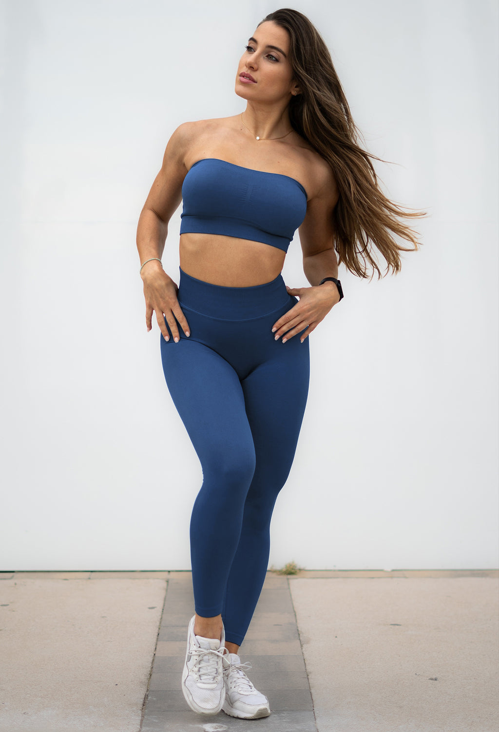 front profile view of model standing outside wearing our cheeky seamless leggings and matching bandeau in the color galaxy